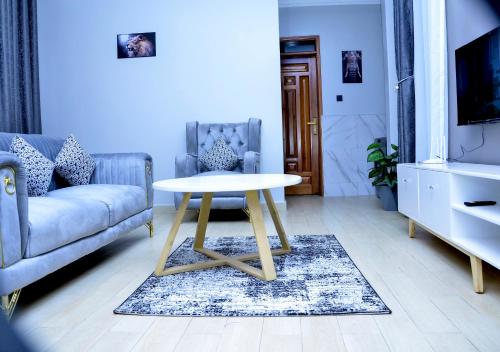 a living room with a table and a couch at Dreamy Den Suites Kiwatule in Kampala