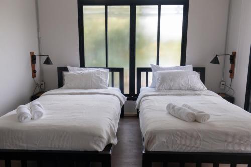 two beds sitting next to each other in a bedroom at liaw base house in Bangkok