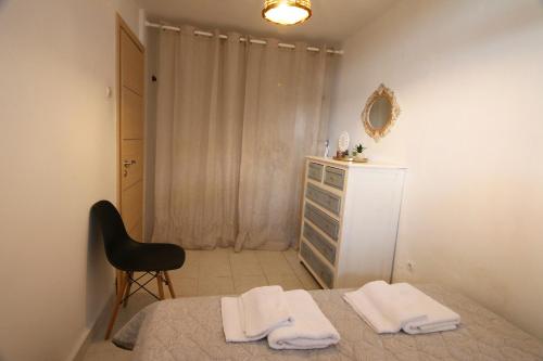 The Lemoni House -Skyathos- 1-bedroom apartment في مدينة سكياثوس: غرفة نوم بسرير وكرسي وخزانة