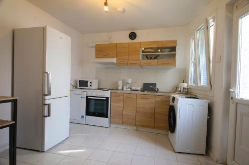 The Lemoni House -Skyathos- 1-bedroom apartment في مدينة سكياثوس: مطبخ مع ثلاجة بيضاء وغسالة صحون