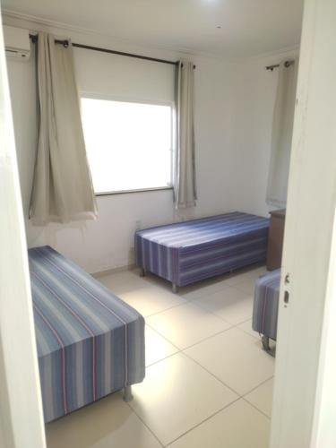 zwei Betten in einem Zimmer mit Fenster in der Unterkunft Casa na praia de Jatobá in Barra dos Coqueiros