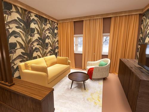 a living room with a yellow couch and a chair at Alpenhotel St.Christoph in Sankt Christoph am Arlberg