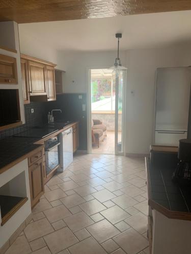 Il comprend une cuisine avec du carrelage et une porte ouverte. dans l'établissement Maison 6 personnes veranda et jardin, à Cherbourg en Cotentin