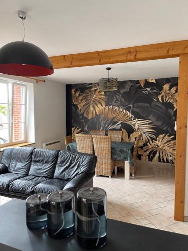 un salon avec un canapé et une table dans l'établissement Maison 6 personnes veranda et jardin, à Cherbourg en Cotentin