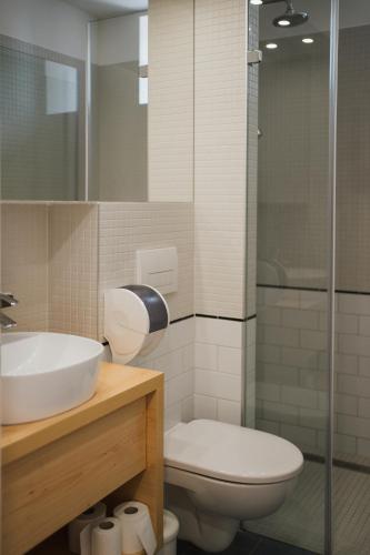 a bathroom with a toilet and a sink and a shower at Tornácos Hotel - Hegykő in Hegykő