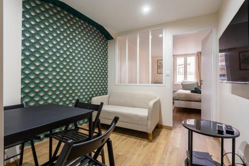 un salon avec une table et un canapé dans l'établissement Appartement climatisé centre-ville 5 minutes de la cathédrale, à Strasbourg
