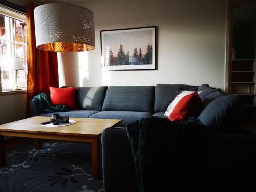 a living room with a blue couch and a table at Bästa läget i Grönklitt! in Orsa