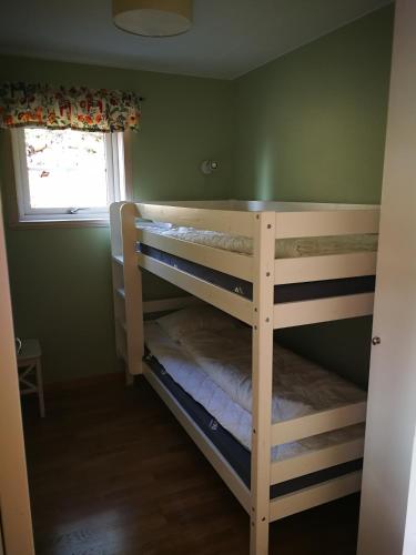 a bedroom with two bunk beds with a window at Bästa läget i Grönklitt! in Orsa