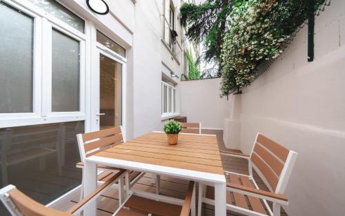 une table et des chaises en bois sur un balcon dans l'établissement Apartment center of Paris with terrace by Studio Prestige, à Paris