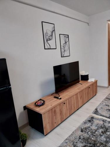 un soggiorno con TV a schermo piatto su un tavolo in legno di vApartament 2 central a Hunedoara