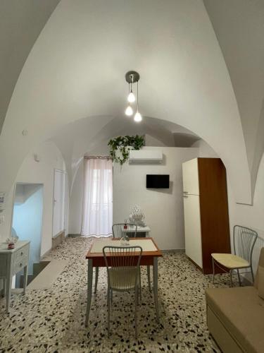 a kitchen and dining room with a table and a refrigerator at The White Rose in Ceglie Messapica