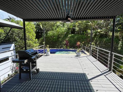 a patio with a grill and a swimming pool at Casa Ker Lumar in Uvita