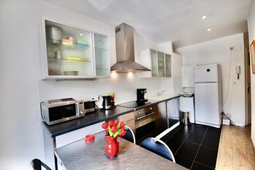 une cuisine avec une table avec un vase de fleurs dessus dans l'établissement Le Gambetta 2P 262, à Cannes