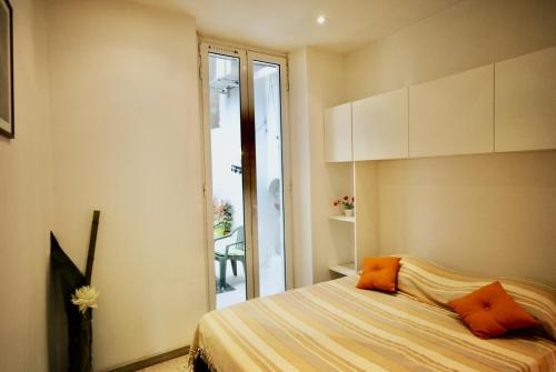 - une chambre dotée d'un lit avec des oreillers orange dans l'établissement Le Gambetta 2P 262, à Cannes