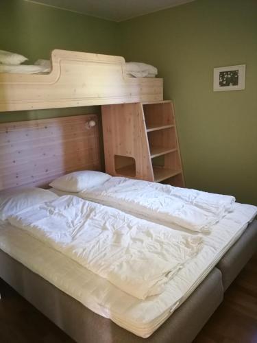 a bedroom with a bunk bed with white sheets at Bästa läget i Grönklitt! in Orsa
