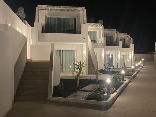 a row of white houses at night with lights at Kikere Studios in Puerto del Carmen
