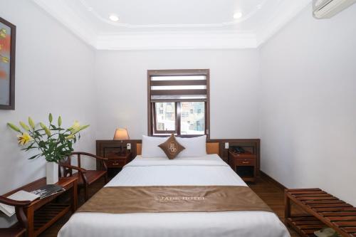 a bedroom with two beds and a window at Jade Hotel in Hue