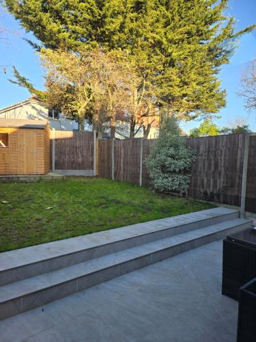 a backyard with concrete steps and a fence at Dreams House in Hendon
