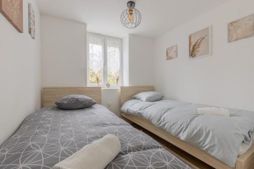 une chambre avec deux lits et une fenêtre dans l'établissement Charmant appartement proche centre ville, à Metz