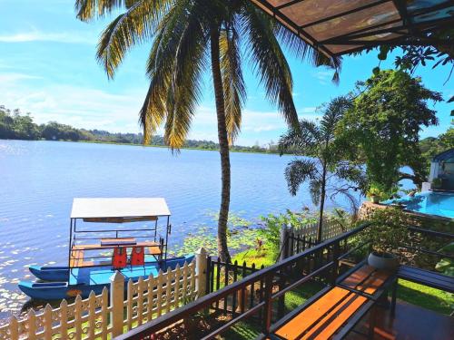 a boat sitting on the water next to a fence at MYH - Lake Front Pvt Villa with Staff and Includes FREE Breakfast of your choice in Bandaragama