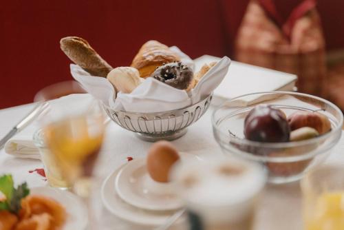 a table topped with a bowl of pastries and bread at Alpenhotel St.Christoph in Sankt Christoph am Arlberg