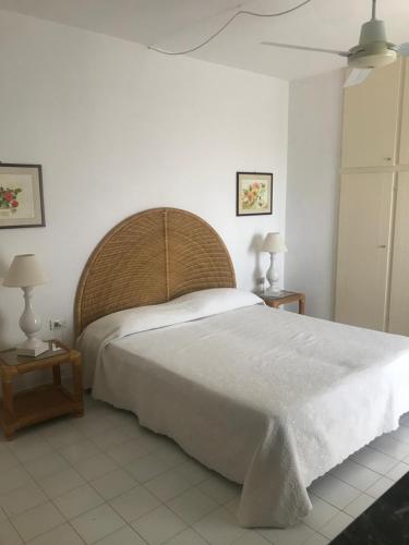 een slaapkamer met een groot wit bed en 2 tafels bij Villa Degli Olivi in Pula