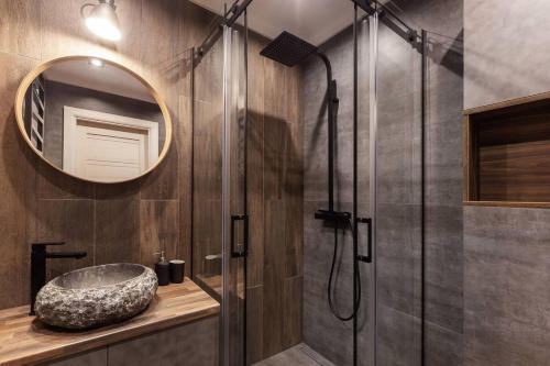 ein Badezimmer mit Waschbecken und Dusche mit Spiegel in der Unterkunft Modern Svencelė Cottage II-Friends and Family in Svenele