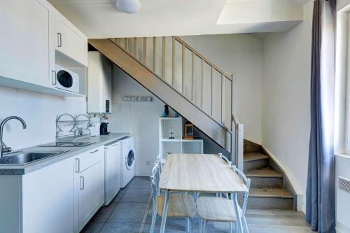 une cuisine avec une table en bois et un escalier dans l'établissement Bluestay 135 - Charming apartment, à Bagnolet