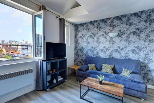 Una sala de estar con un sofá azul y una ventana. en Bluestay 135 - Charming apartment, en Bagnolet