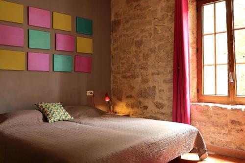 - une chambre avec un lit et un mur coloré dans l'établissement Gîte des Papillons, à Plavilla
