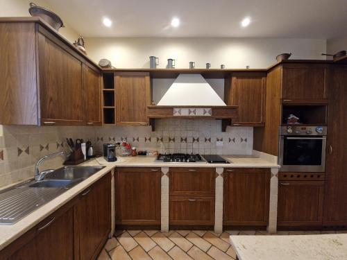 a kitchen with wooden cabinets and a sink at B&B Casa Ciarpella in Montegranaro