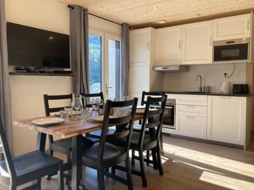 - une cuisine avec une table et des chaises en bois dans l'établissement Appartement refait à neuf dans villa, à Villard-de-Lans