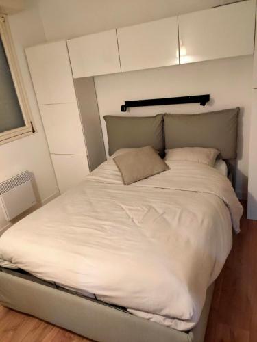 Cette petite chambre comprend un grand lit blanc. dans l'établissement La Mer, la plage, le sable, à Boulogne-sur-Mer