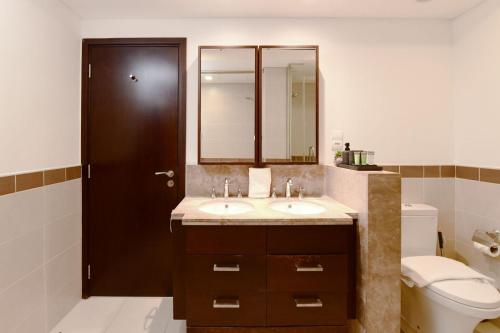 a bathroom with a sink and a toilet and a mirror at Burj Khalifa Fireworks View Downtown - One Bedroom Apartment in Dubai