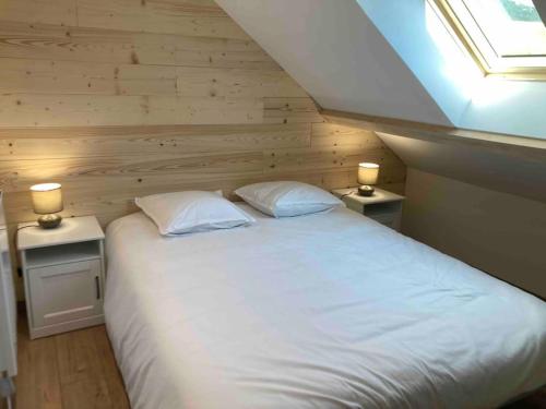 une chambre avec un lit blanc avec deux tables de nuit dans l'établissement Appartement refait à neuf dans villa, à Villard-de-Lans