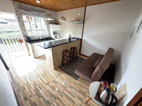 a kitchen and living room with a couch and a table at Apartamento Nuvem · Apartamento Nuvem 15 min centrinho in Campos do Jordão