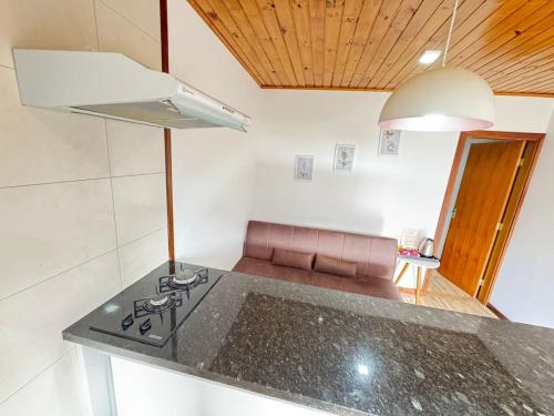 a kitchen with a stove top in a room at Apartamento Nuvem · Apartamento Nuvem 15 min centrinho in Campos do Jordão