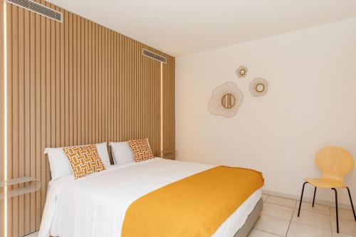 a bedroom with a bed and a chair in it at Côté Croisette LUXE - 2BdR 2 bthR 2 toilets -Terrace, AC, parking & lift in Cannes
