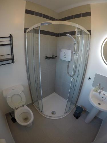 a bathroom with a shower and a toilet and a sink at Seagull Cottage B&B in Portmagee