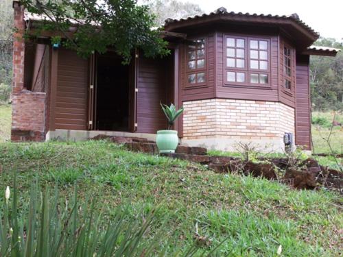 a brown house with a potted plant in front of it at Pousada Esperança in Osório