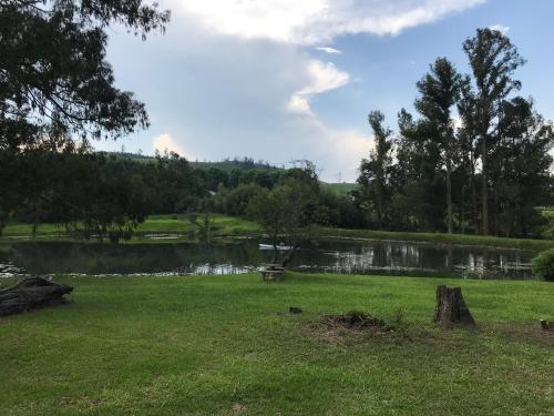 a park with a lake and trees in the background at The Retreat Country Lodge in Romelcoh