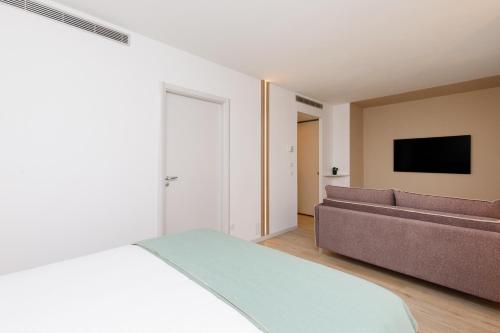 a bedroom with a bed and a couch at Côté Croisette LUXE - 2BdR 2 bthR 2 toilets -Terrace, AC, parking & lift in Cannes