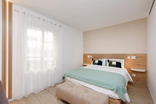 a bedroom with a bed and a large window at Côté Croisette LUXE - 2BdR 2 bthR 2 toilets -Terrace, AC, parking & lift in Cannes