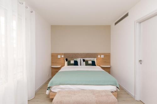 a bedroom with a bed and white walls at Côté Croisette LUXE - 2BdR 2 bthR 2 toilets -Terrace, AC, parking & lift in Cannes