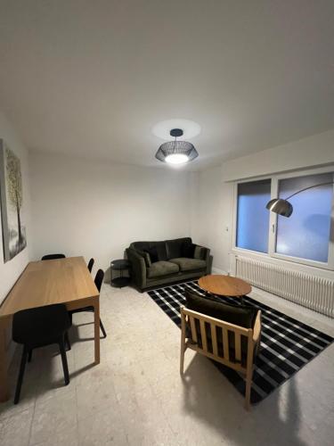 un salon avec un canapé et une table dans l'établissement Cœur de ville, à Lens