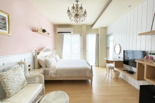 a bedroom with a bed and a couch and a tv at 阿爾法民宿AlphaVilla in Hengchun