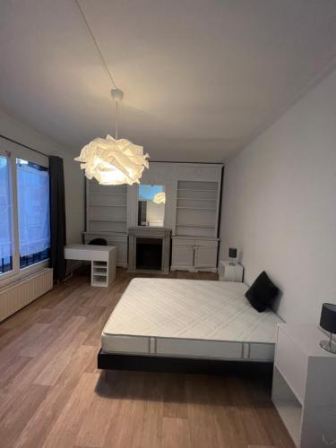 una camera da letto con un letto e un lampadario di Cœur de ville a Lens