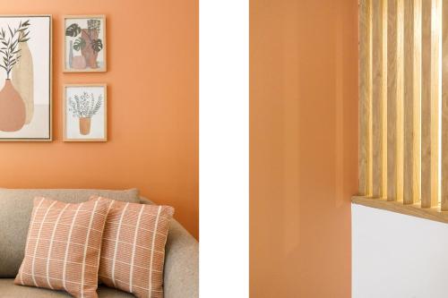 a living room with orange walls and a couch at Côté Croisette LUXE - 2BdR 2 bthR 2 toilets -Terrace, AC, parking & lift in Cannes