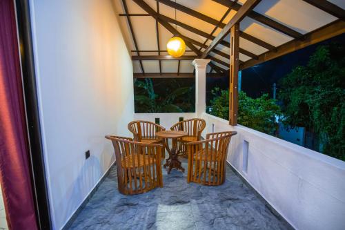Un patio con sillas y una mesa en un balcón. en Sri Villa, en Dodanduwa