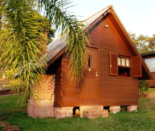 a small wooden house with a palm tree next to it at Pousada Esperança in Osório